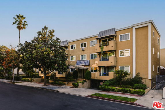 Front view of a multi-story apartment building with balconies and windows.