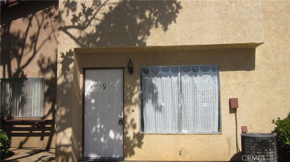 Front view of a house with a white door and large window.