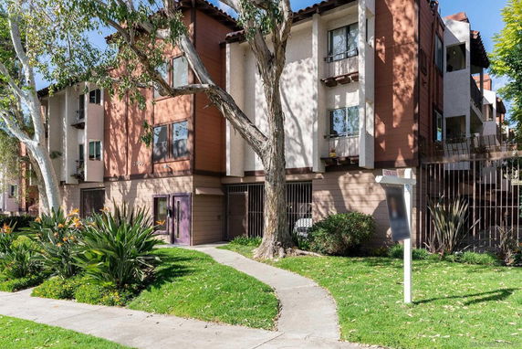 Front view of a multi-story apartment building with balconies.