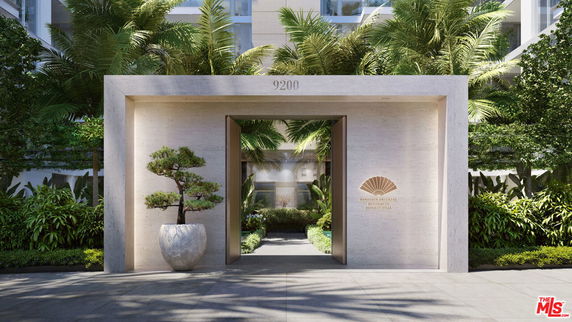 Entrance view of a building with a modern stone archway and lush greenery.