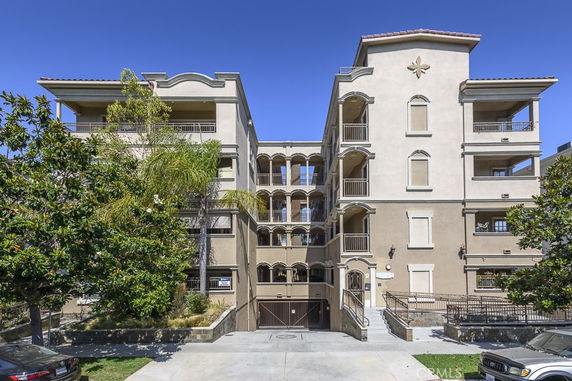 Front view of a multi-story apartment building with balconies.