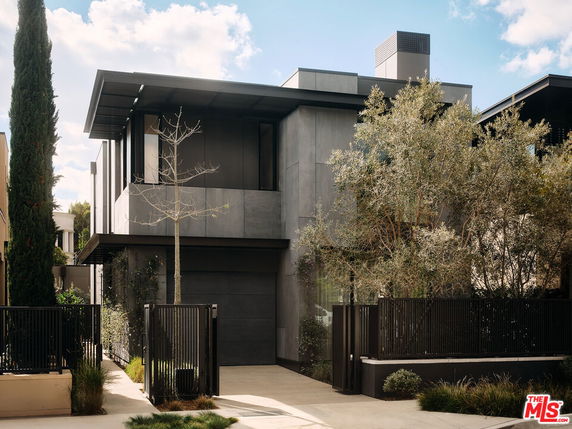 Front view of a modern two-story house with a sleek design and dark exterior.