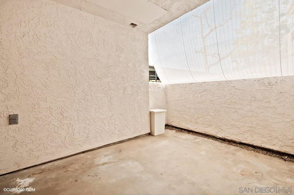 Small outdoor space with textured walls and a covered ceiling.
