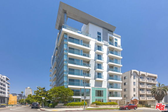 Front view of a modern multi-story apartment building with large balconies.
