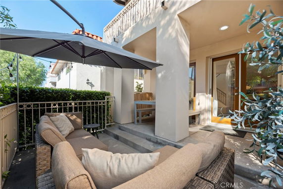 Front view of a house with a small outdoor seating area and umbrella.