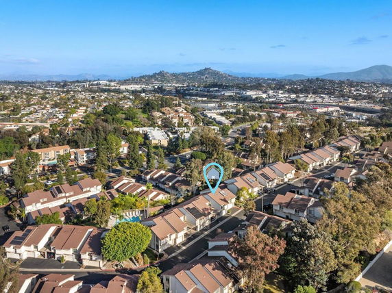 Aerial view of a residential neighborhood with rows of houses and surrounding landscapes.