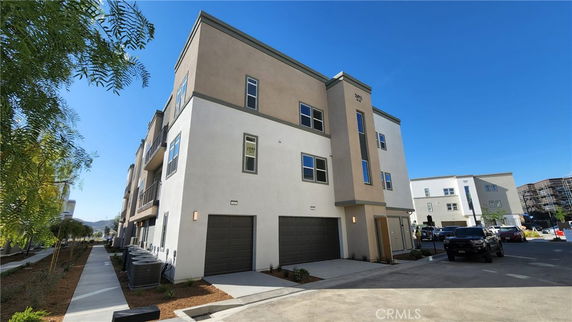 Front view of a multi-story building with garages on the ground floor.