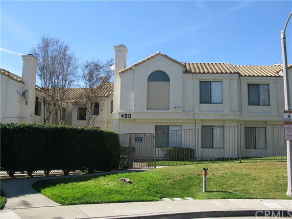 Front view of a two-story residential building with a gated entrance.