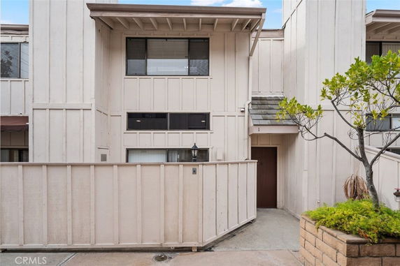Front view of a multi-story house with a fenced entryway.