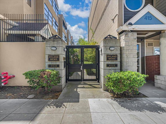Front view of a building entrance with a metal gate and surrounding walls.