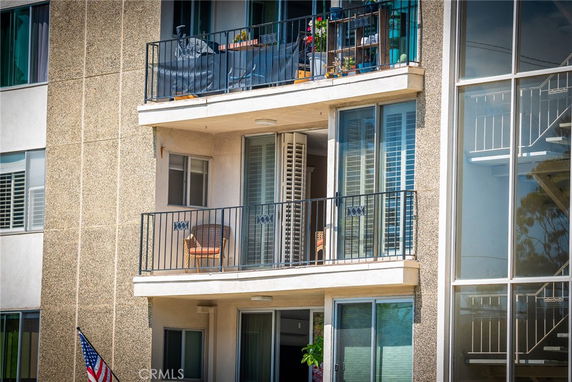 View of a multi-story building with balconies and large windows.