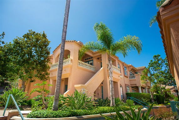 Front view of a two-story house with balconies and stucco exterior.