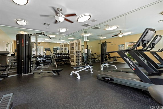 Indoor gym area with fitness equipment and mirrors.
