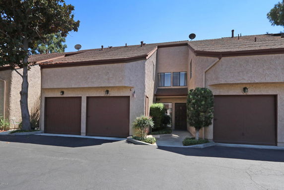 Front view of a multi-story townhouse with two garages.