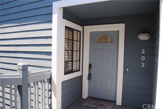 Front view of a house entrance with a blue door and window.