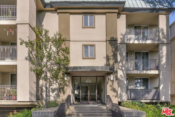 Front view of a multi-story building with balconies and a central entrance.