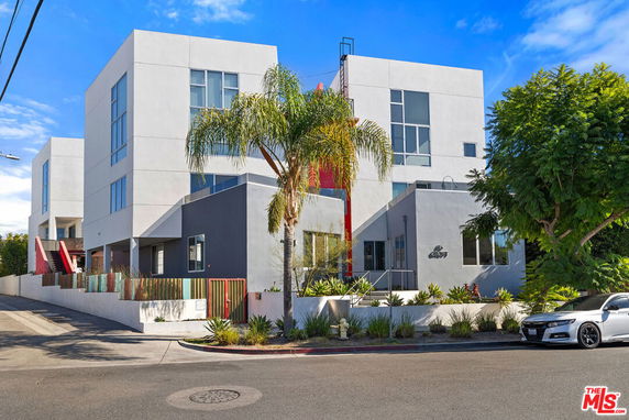 Front view of a modern multi-story building with large windows and geometric design elements.
