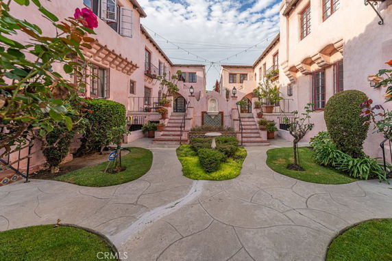 Front view of a two-story residential building with a courtyard and garden pathway.