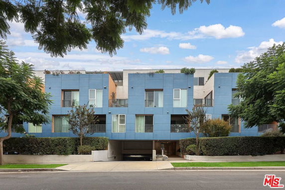 Front view of a modern multi-story building with blue paneling.