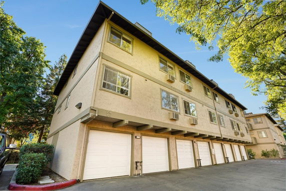 Front view of a multi-story building with multiple garage doors on the ground level.