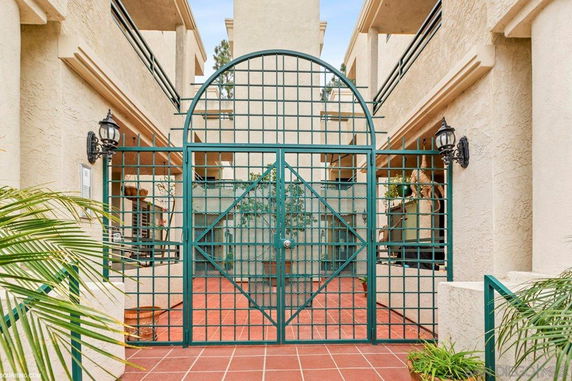 Front view of a multi-story building with decorative metal gate and balconies.