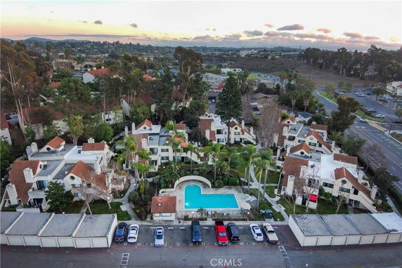 Aerial view of a residential complex with multiple buildings and a central swimming pool.