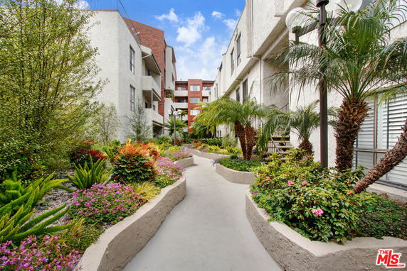 Outdoor view of residential buildings with landscaped gardens and pathways.