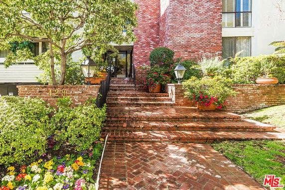 Front view of a house with brick steps and a garden entrance.