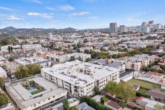 Panoramic view of a cityscape with buildings and distant hills.
