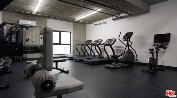 Indoor gym area with exercise equipment including treadmills, exercise bike, and weight machines.
