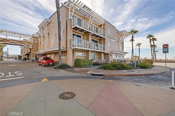 Front view of a multi-story beachfront building with apartments and balconies.