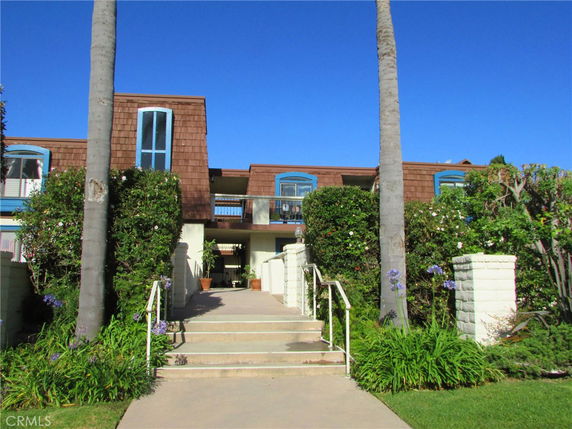 Front view of a multi-story building with a wooden facade and blue-framed windows.