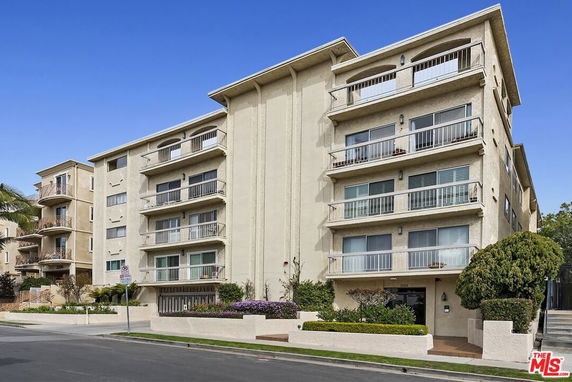 Front view of a multi-story apartment building with balconies.