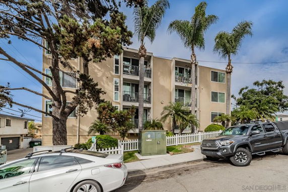 Front view of a multi-story apartment building with balconies.