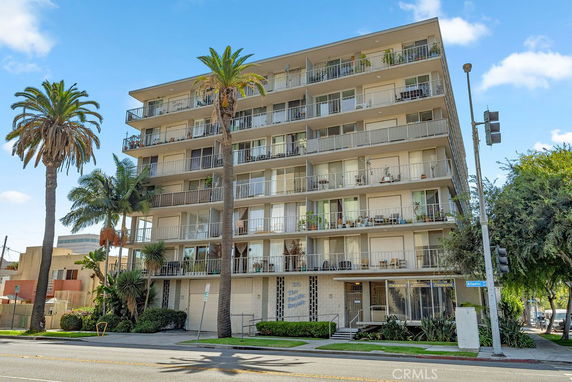 Front view of a multi-story apartment building with balconies.