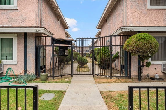 Front view of two adjacent residential buildings with gated entrance.