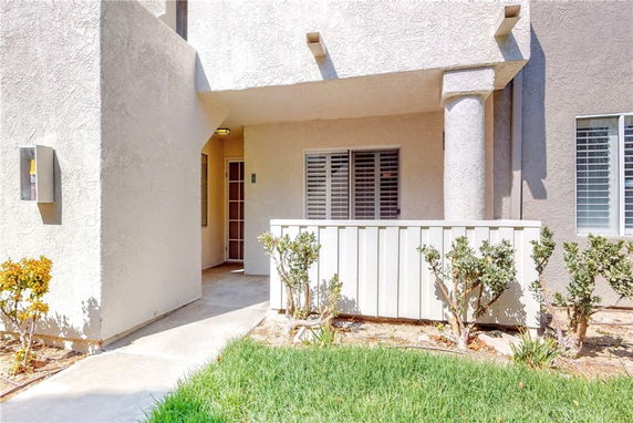Front view of a building with a small porch and patio area.