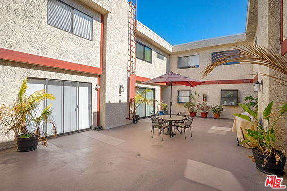 Outdoor view of a building's courtyard with seating area and potted plants.