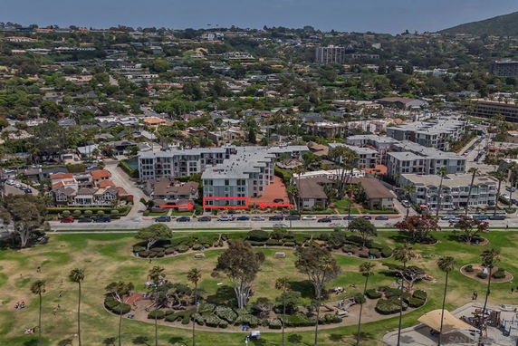 Aerial view of a residential area with multiple buildings and a park in the foreground.