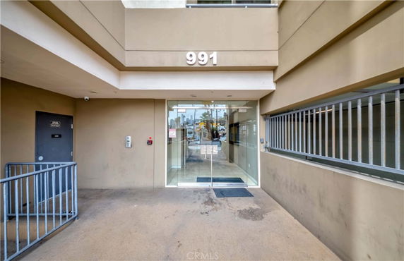 Entrance view of a building with a glass door and railing.