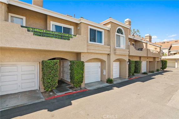 Front view of a two-story residential building with garage spaces.