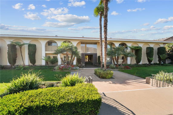 Front view of a two-story building with a central entrance and landscaped garden.