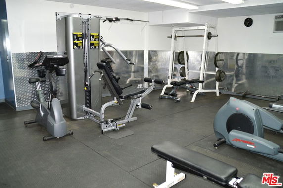 Indoor gym area with exercise equipment and weight machines.