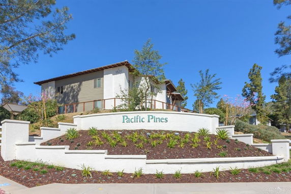 Front view of a residential building with the name 'Pacific Pines' on a sign.