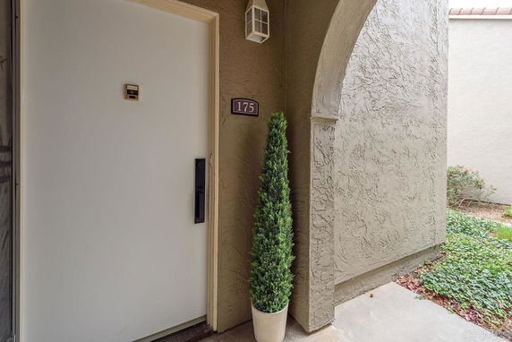 Front view of a house entrance with a white door and arched entryway.