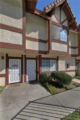 Front view of a multi-story building with timber framing and decorative windows.