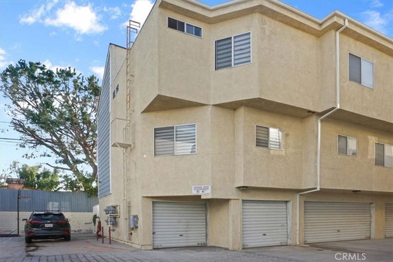 Front view of a multi-story building with a garage on the ground level.