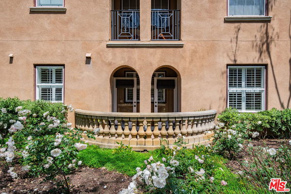 Front view of a building with a small balcony and arched entrance.