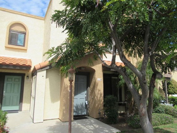 Front view of a two-story house with arched windows and a tiled roof.