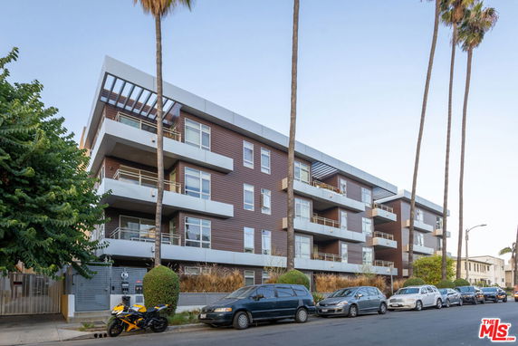 Front view of a modern multi-story apartment building with balconies.